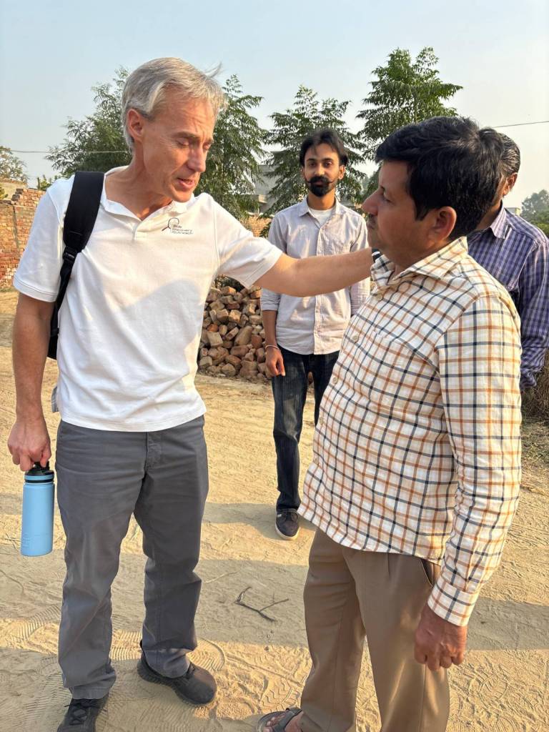 Dr. Michael Wedman prays with a man in Punjab, India